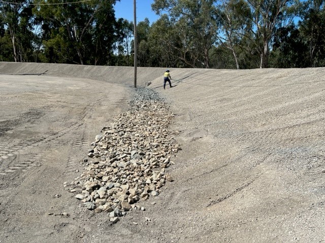 A worker is shown in the distance of a huge flood levee in Mooroopna, Victoria Australia.